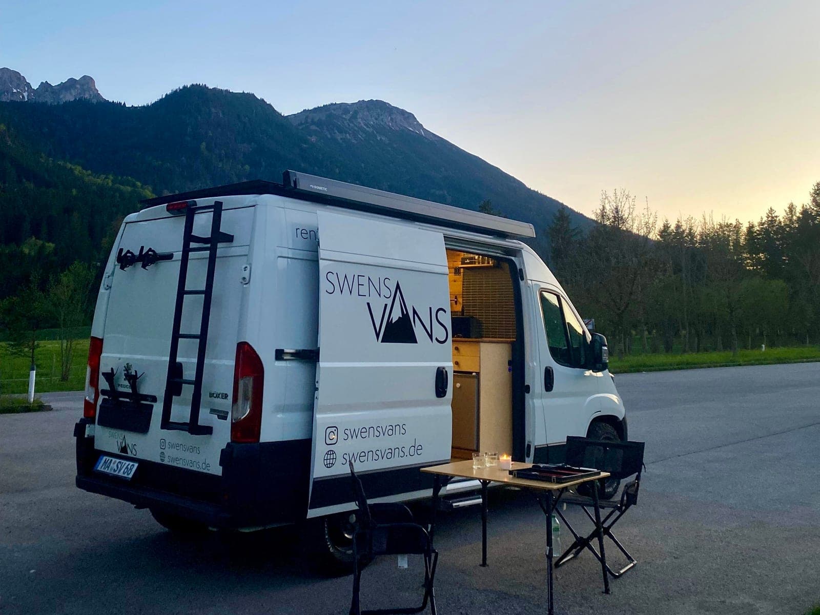 SVAN 01 Campervan in den Alpen bei Dämmerung mit Markise und Tisch